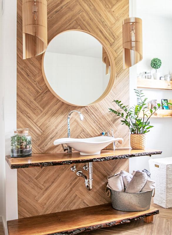 bamboo and natural wood bathroom sink with round mirror and herringbone wall panelling