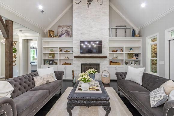 white living room with fireplace and built in shelving.